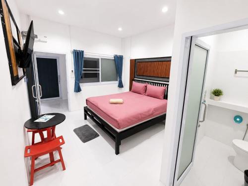 a bedroom with a pink bed and a bathroom at Dive In Koh Tao in Ko Tao