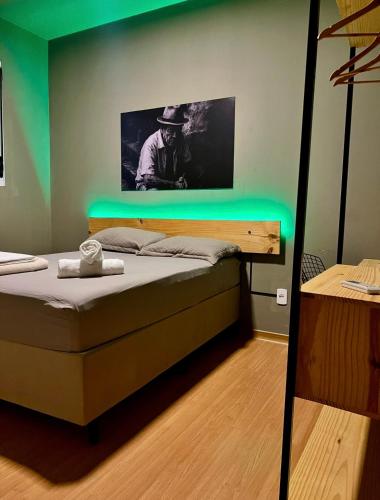 a bedroom with a bed with a green light on it at Reserva 1202 - Hospedagem in Cabedelo