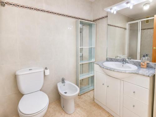 a white bathroom with a toilet and a sink at Ventura Park CC3 in Salou