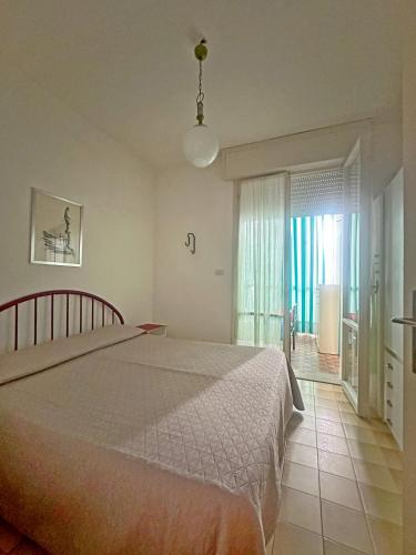 a bedroom with a large bed and a window at Residence MARE App Alga 24 in Lido delle Nazioni