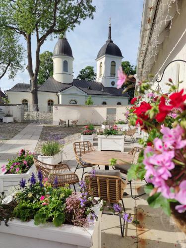 a courtyard with chairs and flowers in front of a building at Arte Güldenstubbe Residences in Kuressaare