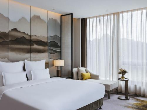 a hotel room with a large bed and a window at Pullman Fuzhou Tahoe in Fuzhou