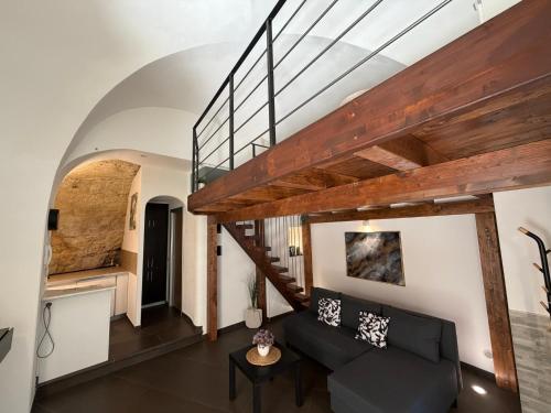 a living room with a black couch and a staircase at CasaCastellett in Modica