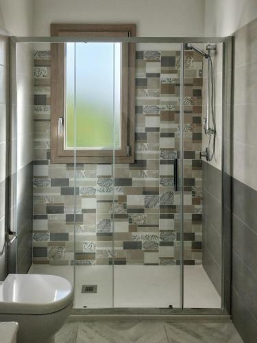 a bathroom with a glass shower with a toilet at AmarMare Bed&Breakfast in Trappeto