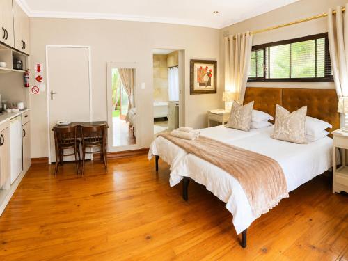a bedroom with a large bed and a kitchen at Ladera - Vista Self-catering Guesthouse in Paarl