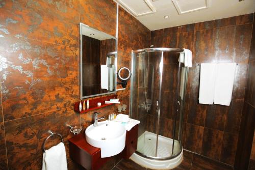 a bathroom with a sink and a shower at Al Manzil Hotel Bahrain in Juffair