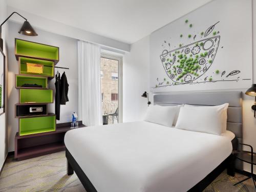 a bedroom with a white bed and green shelves at Ibis Styles Jerusalem City Center - An AccorHotels Brand in Jerusalem