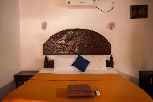 a bed with a wooden headboard in a bedroom at West Bay Palm Tree Beach Resort in Varkala
