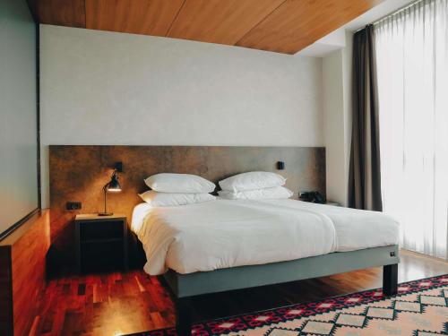a bedroom with a large bed with white sheets and pillows at ibis Styles Sarajevo in Sarajevo