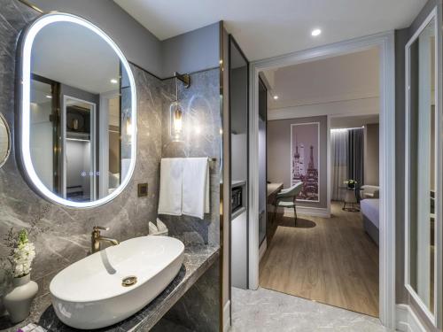 a bathroom with a sink and a mirror at Mercure Shanghai Global Harbour in Shanghai