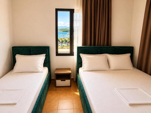 two beds in a room with a window at Villa Lions in Ksamil