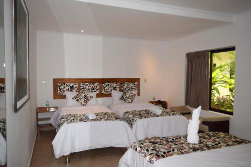 a hotel room with two beds and a window at Hotel Jungle House in Iquitos