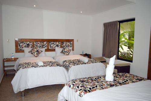 a bedroom with two beds and a window at Hotel Jungle House in Iquitos