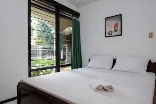a bedroom with a bed with two towels on it at Hotel Srikandi Semarang RedPartner in Candi