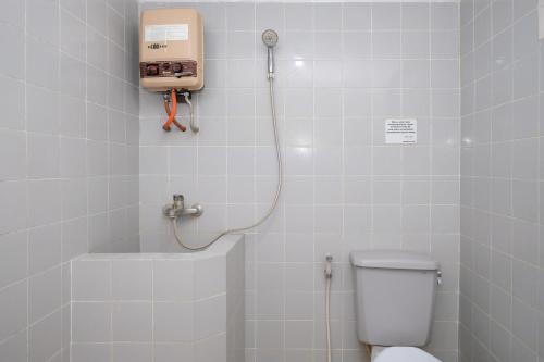 a bathroom with a toilet and a shower in it at Hotel Srikandi Semarang RedPartner in Candi