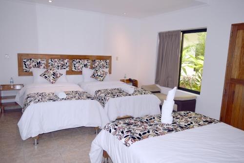 a bedroom with two beds and a window at Hotel Jungle House in Iquitos