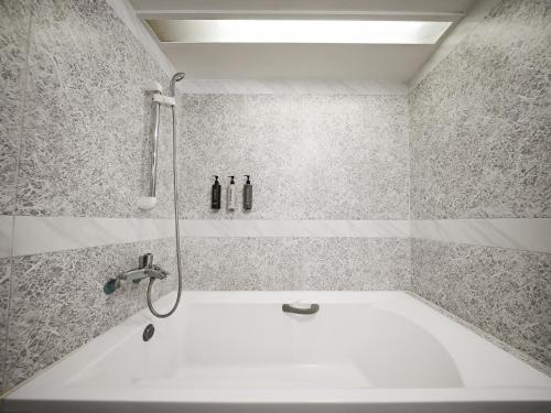 a bathroom with a bath tub with a shower at Guide Hotel Taoyuan Fuxing in Taoyuan