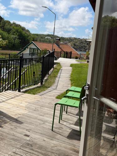 a green bench on a porch with a fence at Hem till Bengt in Kungshamn