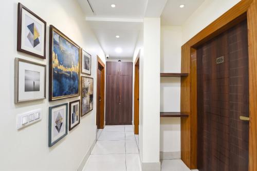 a hallway with pictures on the walls and a wooden door at FabHotel Samarth Residency By the Arrow in New Delhi