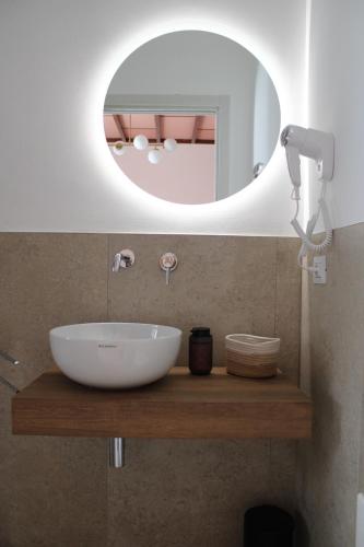 a bathroom with a white sink and a mirror at Dimora Letizia, Apulian Rooms in Sammichele di Bari