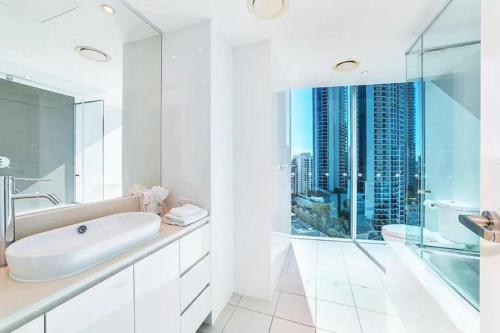 a white bathroom with a sink and a shower at Luxurious 2 Bedroom Apartment - Ocean View in Gold Coast
