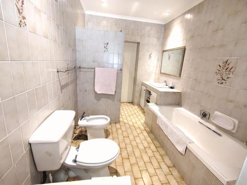 a bathroom with a toilet and a tub and a sink at Francolin's Rest Guest Suite in Sweet Valley