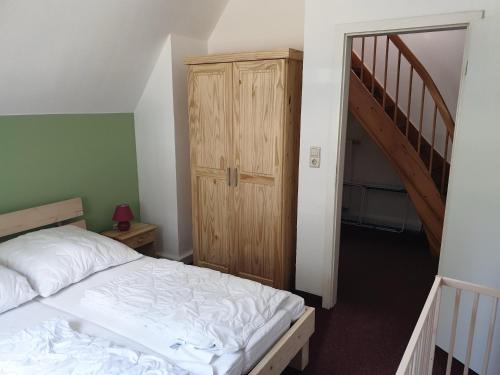 a bedroom with a bed and a wooden closet at Sauberghaus Wohnung 2 in Breitenbrunn