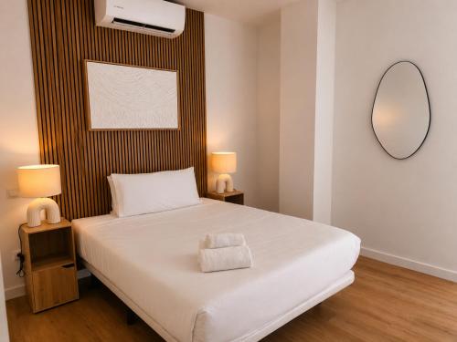 a bedroom with a large white bed with a mirror at Aparthotel Fuenlabrada Central in Fuenlabrada