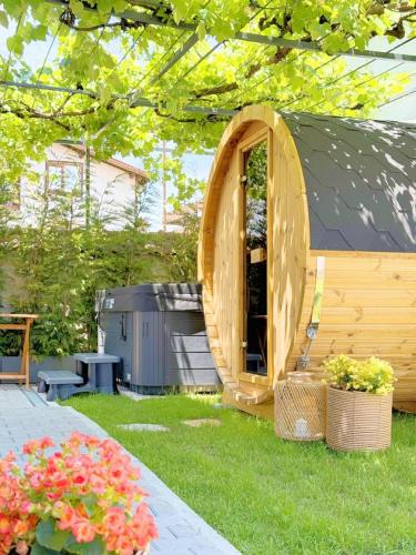 a gazebo in a yard with some flowers at Chalet Charm - Private Mountain Retreat with Sauna, Jacuzzi & Kids Playroom in Bansko