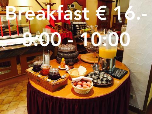 a breakfast table with food and a pitcher of orange juice at Bed & Breakfast du Château - Breakfast not included in Vianden