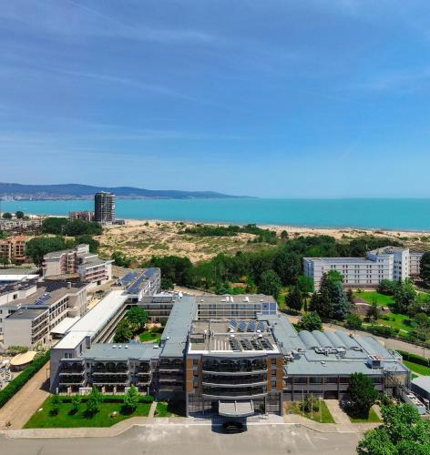 an aerial view of a building with the ocean in the background at Hotel Longosa - All Inclusive Family Hotel near the beach in the peaceful southern part of Sunny Beach in Sunny Beach