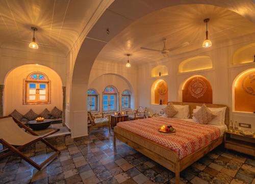 a bedroom with a bed and a table and chairs at Sitaram Bhawan - A 250-Year- Old Heritage Haveli, Jaipur in Jaipur
