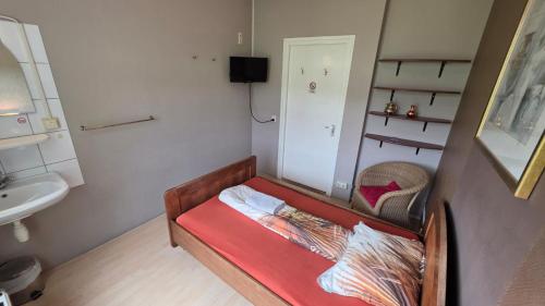 a small room with a bed and a sink at Hotel Restaurant Roerdinkhof in Winterswijk