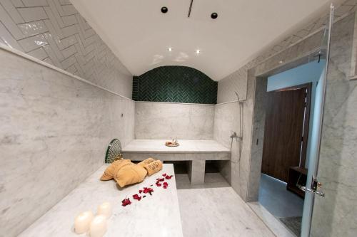 a room with a bath tub and a table with flowers at Riad Yacout in Meknès