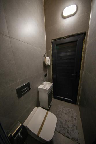 a bathroom with a toilet and a black door at Sky Line Villa in Ardeşen