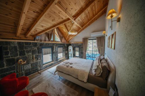 a bedroom with a large bed in a room with wooden ceilings at Sky Line Villa in Ardeşen