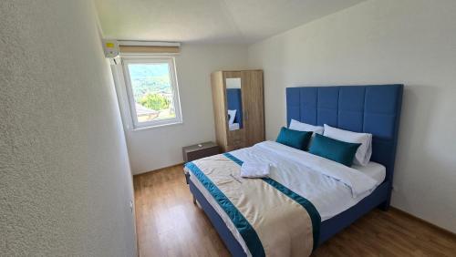 a bedroom with a blue bed with a blue headboard at منتجع سراييفو - Sarajevo Resort in Sarajevo