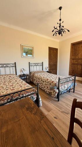 a bedroom with two beds and a chandelier at Piano Piano Affittacamere in Andagna