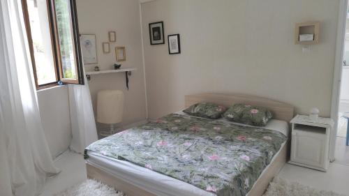 a bedroom with a bed with a floral comforter at Villa Toni in Varna City
