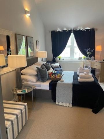 a bedroom with a bed with a blue curtain at Wisteria House Boutique Stay Marlow in Marlow