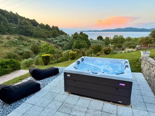 a hot tub on a patio with a view at STONEHOUSE & CASA AL SOLE e AL MARE in Nea Roda