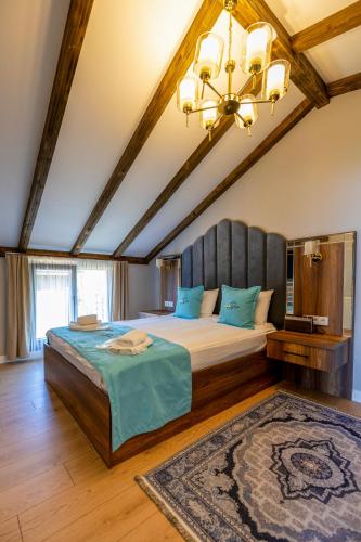 a bedroom with a large bed and a chandelier at Poison Garden Suite & SPA in Gözalan