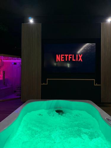 a hot tub in front of a netflix sign at MIRAGE47SPA - Private Spa Suite with Jacuzzi & Sauna in Marbella in Marbella