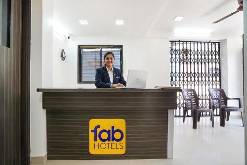 a woman standing at a reception desk with a laptop at FabHotel Destination 42 - Nr Pheonix Mall in Kharadi
