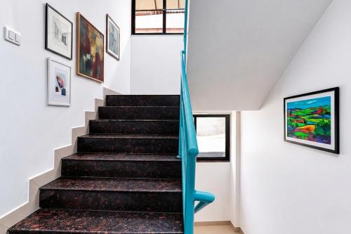 a staircase in a house with a blue rail at FabHotel Destination 42 - Nr Pheonix Mall in Kharadi