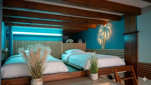 two beds in a room with blue walls at Beach apartment - Ocean sunset full view in Meschers-sur-Gironde