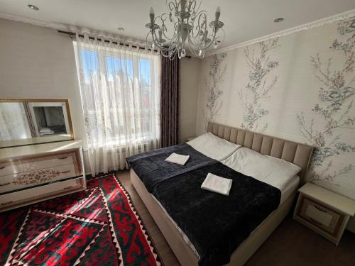 a bedroom with a bed and a chandelier at Guest house Nuri in Karakol