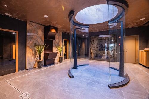 a large lobby with a glass elevator in a building at BIRGÉS HOTEL Lifestyle and View in Balatonfüred