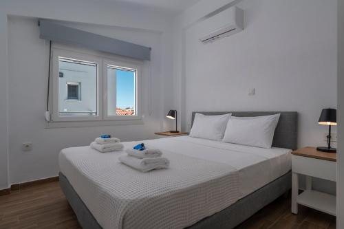 a bedroom with a white bed with towels on it at SLV Irida Apartment in Ofrínion