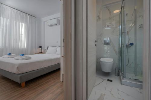 a bathroom with a bed and a glass shower at SLV Irida Apartment in Ofrínion